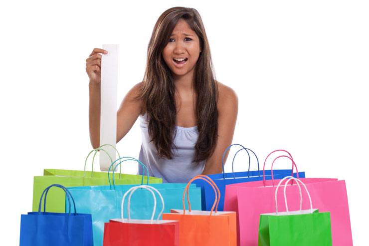 woman with shopping bags shocked at her receipt after spending too much