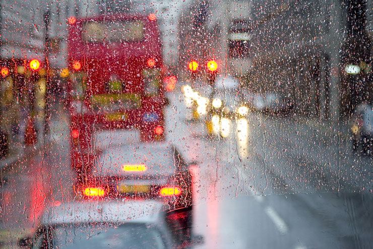 London rain view to red bus through rain-specked window