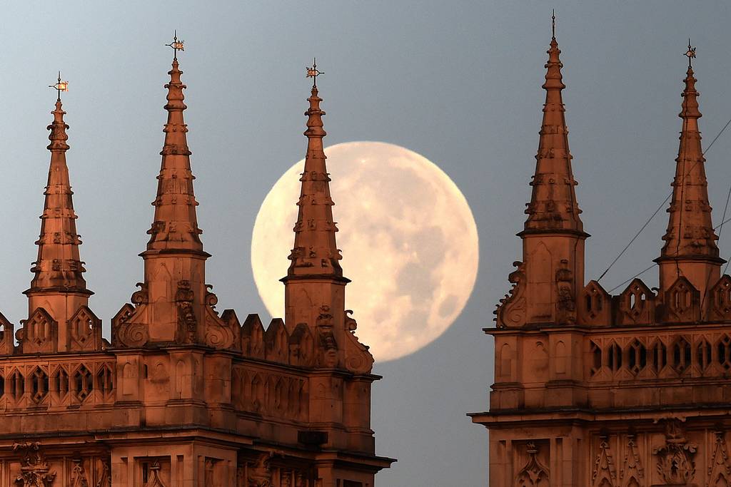 The supermoon is seen through the spires of Westminster